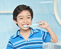 Child brushing teeth with blue toothbrush