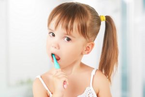 Child brushing teeth with toothbrush